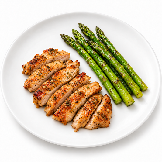Sliced garlic herb chicken thigh with light paprika seasoning and asparagus
